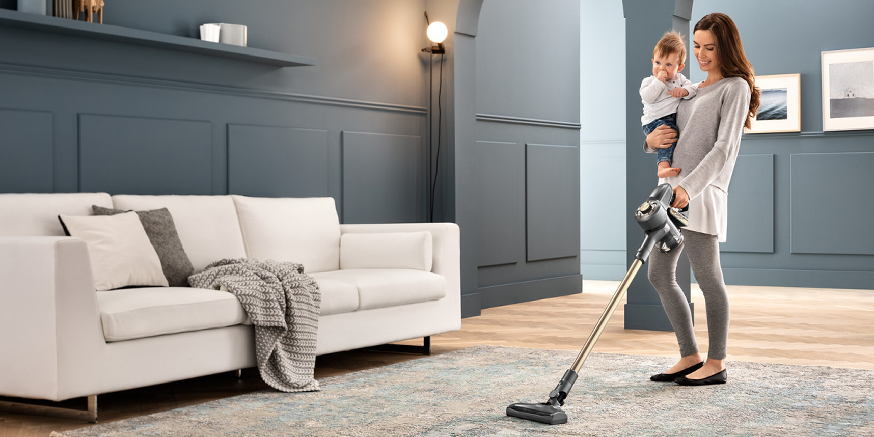 Mutter mit Kind am staubsaugen mit De'Longhi Akkustaubsauger 