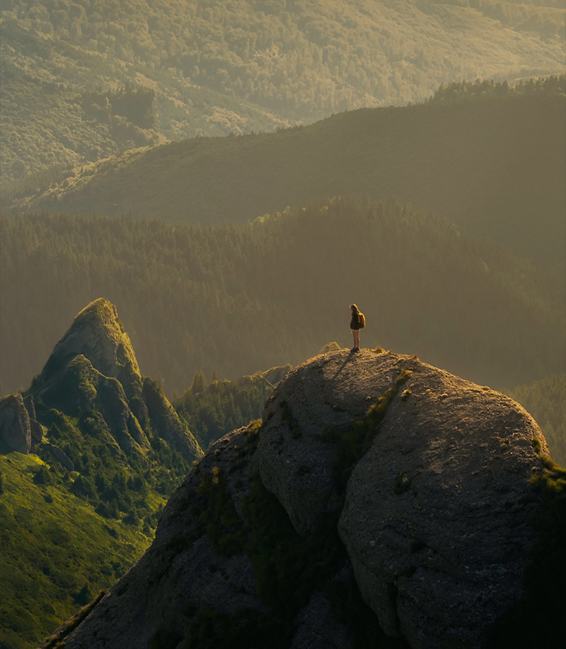 Eine Person die auf dem Gipfel eines Hügels steht