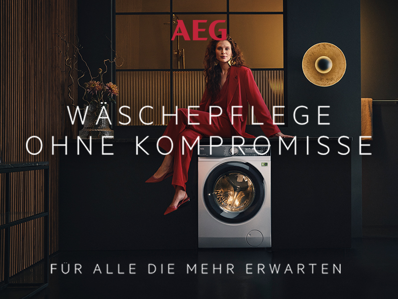 Nachhaltige Wäschepflege mit AEG im Hintergrund ist eine Waschmaschine mit einer rotgekleideten Frau die darauf sitzt