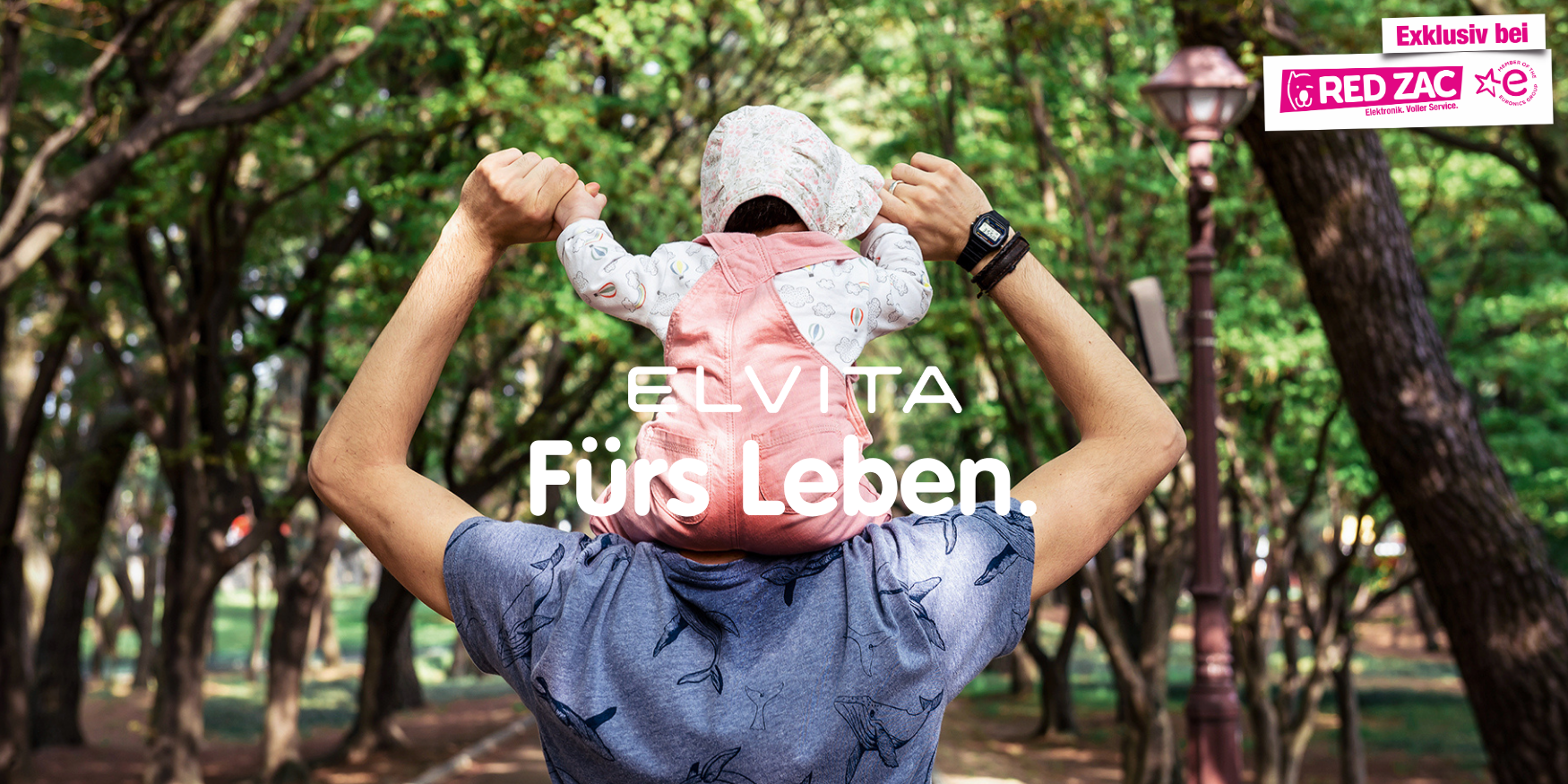 Elvita. Fürs. Leben. Ein Vater der seine Tochter auf seinen Schultern trägt.